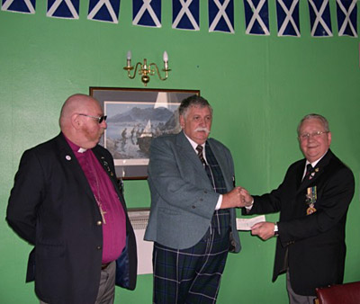 Mr. John Richardson accepts The Handlebar Club's £100 donation from Alex McBride