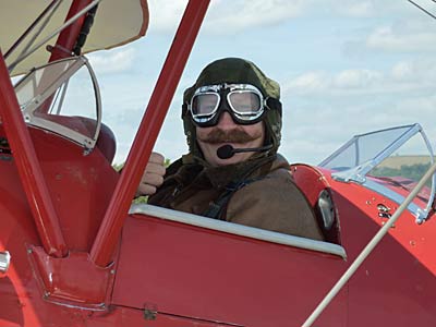 Club member Roger Garbett enjoying his 50th birthday present, a flight in a Tiger Moth, and putting his handlebar to proper use!